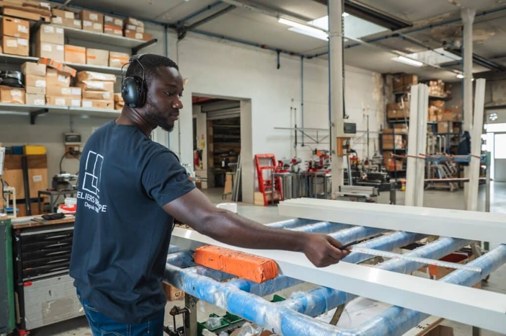 Technicien des Ateliers Dewerpe en train de mesurer une menuiserie