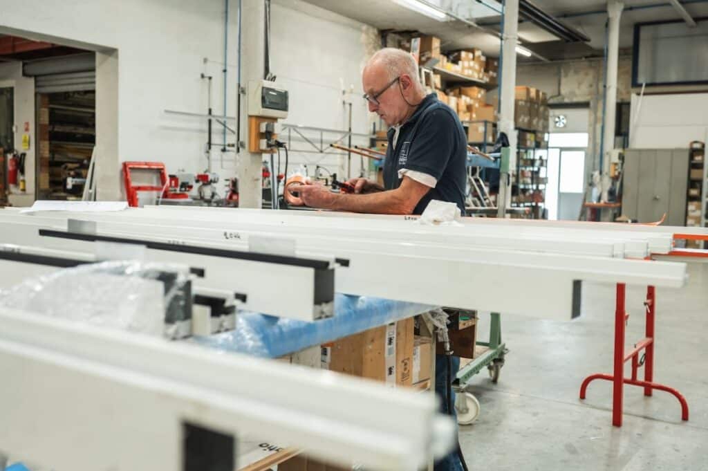 Technicien des Ateliers Dewerpe en train de fabriquer une baie vitrée