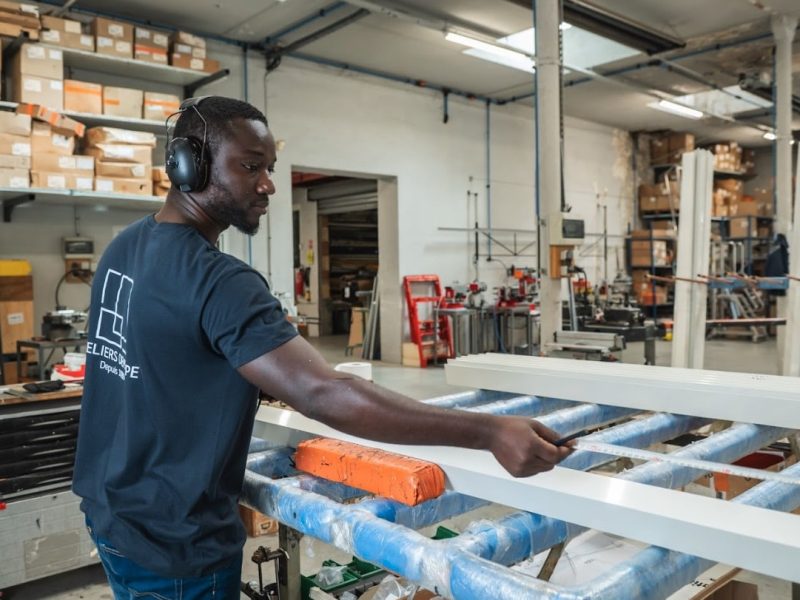 Technicien des Ateliers Dewerpe en train de mesurer une menuiserie