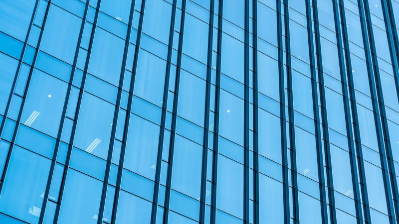 Photo d'une façade vitrée d'un immeuble tertiaire prise du bas vers le haut