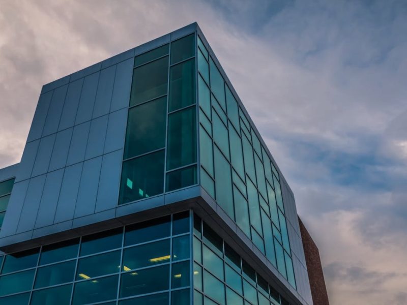 Photo d'une façade vitrée d'un bâtiment tertiaire prise à la tombée de la nuit
